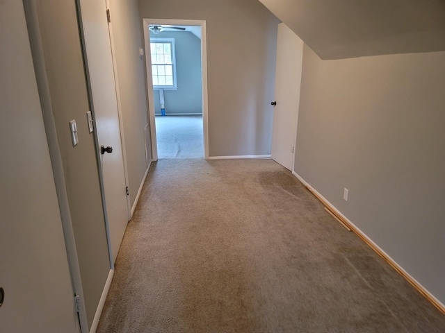 additional living space with lofted ceiling, light colored carpet, and baseboards