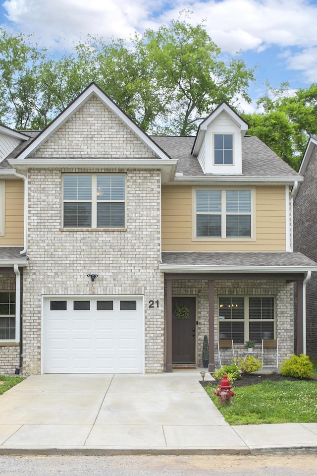 view of front of property featuring an attached garage, driveway, a shingled roof, and brick siding