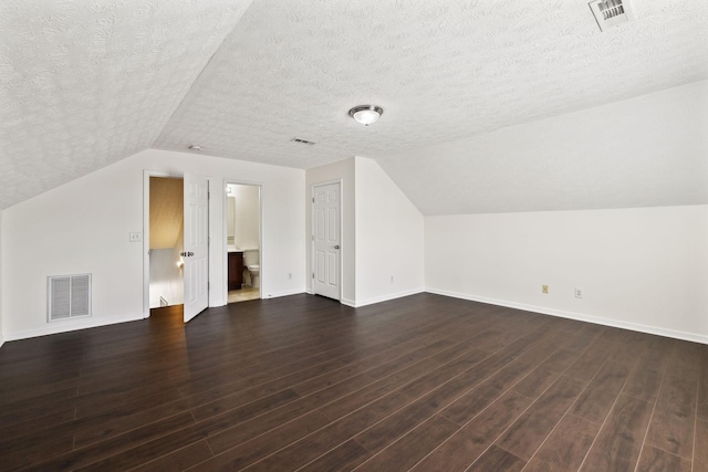 bonus room featuring visible vents and dark wood finished floors