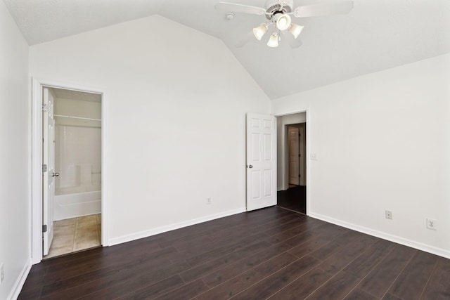 unfurnished bedroom with lofted ceiling, dark wood finished floors, baseboards, and ceiling fan