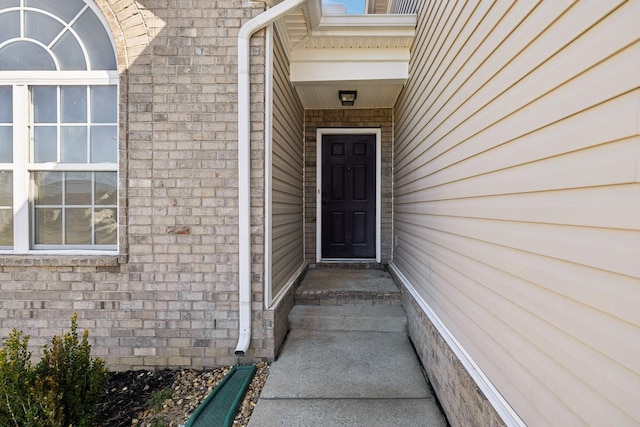 doorway to property featuring brick siding