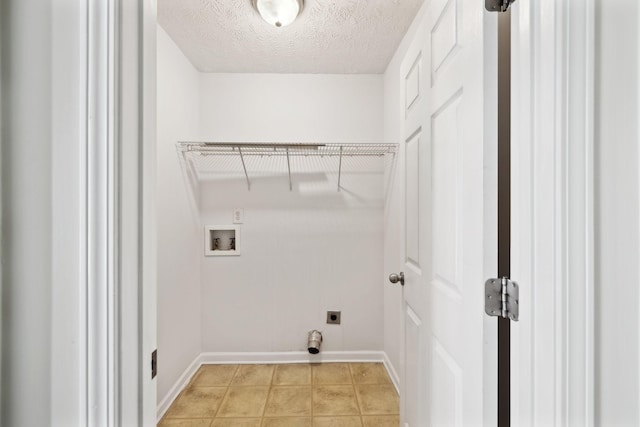 laundry area featuring light tile patterned floors, hookup for a washing machine, hookup for an electric dryer, a textured ceiling, and laundry area