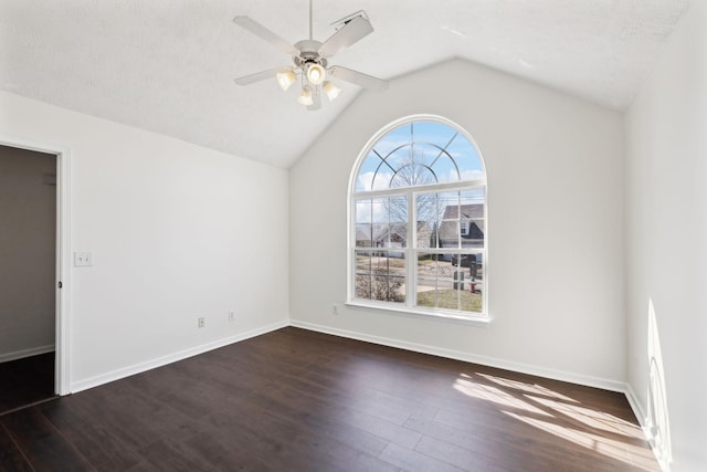 unfurnished room featuring a textured ceiling, wood finished floors, a ceiling fan, baseboards, and vaulted ceiling