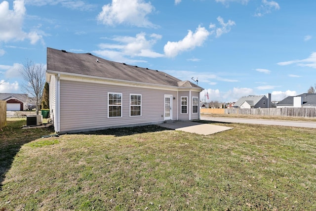 rear view of property with central AC unit, a lawn, a patio area, and fence