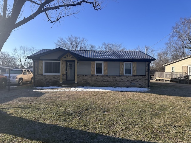 view of front of home with metal roof, brick siding, and a front yard