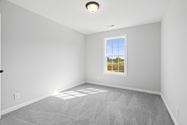 unfurnished room featuring carpet floors, visible vents, and baseboards