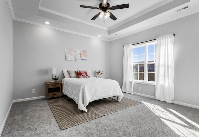 carpeted bedroom featuring ornamental molding, a tray ceiling, visible vents, and baseboards