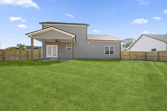 back of property featuring french doors, a fenced backyard, ceiling fan, and a lawn