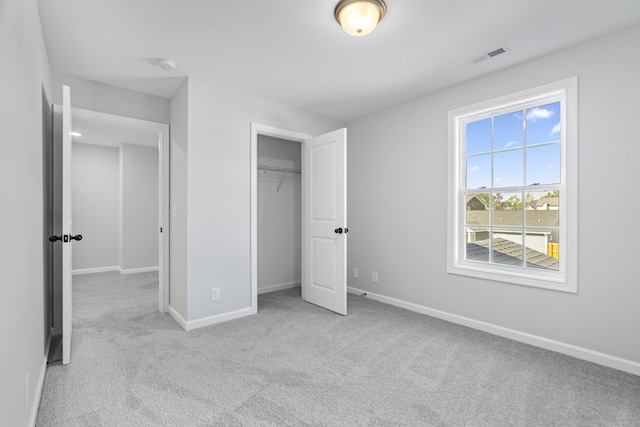 unfurnished bedroom featuring carpet floors, a closet, visible vents, and baseboards