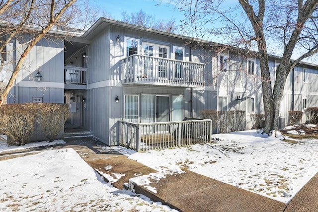 snow covered property with a balcony