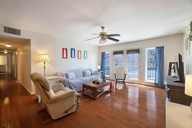 living room with ceiling fan, wood finished floors, visible vents, and baseboards