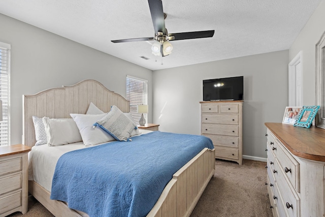 bedroom with light carpet, baseboards, visible vents, ceiling fan, and a textured ceiling