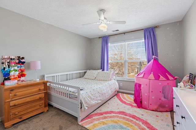 carpeted bedroom featuring visible vents, ceiling fan, a textured ceiling, and baseboards