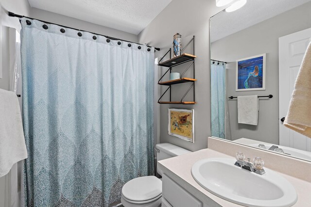 bathroom featuring a textured ceiling, toilet, and vanity