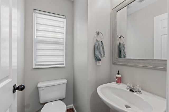 half bathroom featuring a sink and toilet