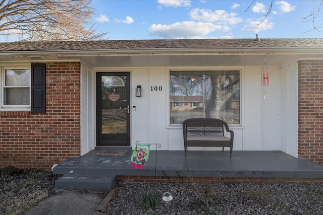 view of exterior entry with brick siding