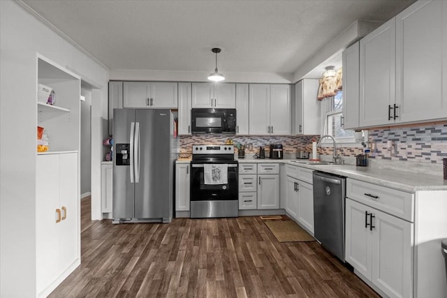 kitchen featuring dark wood-style floors, stainless steel appliances, a sink, and light countertops