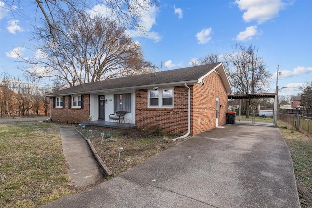 view of front facade with covered porch, brick siding, fence, driveway, and a gate