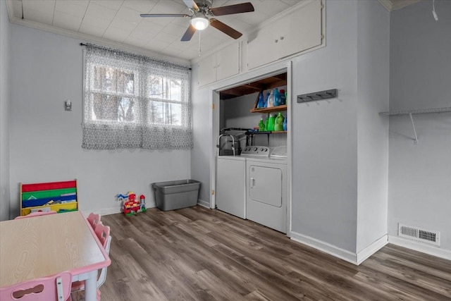 washroom with laundry area, wood finished floors, visible vents, washing machine and clothes dryer, and crown molding