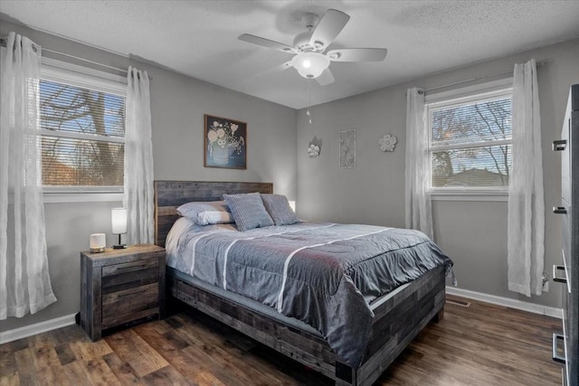 bedroom featuring dark wood-style flooring, ceiling fan, a textured ceiling, and baseboards