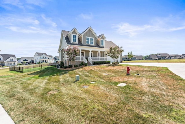 cape cod home featuring a porch, a front yard, fence, and a residential view