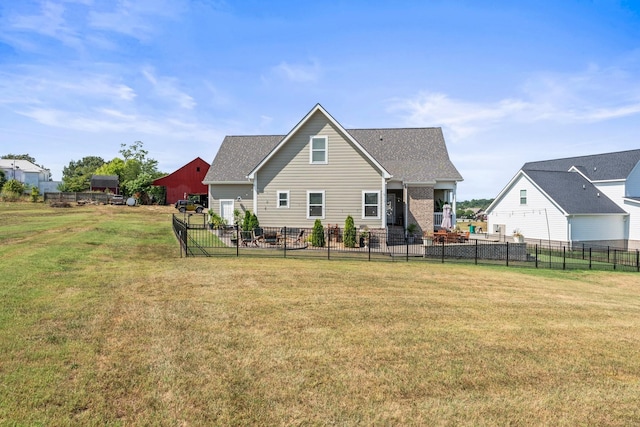 rear view of house featuring a yard and fence