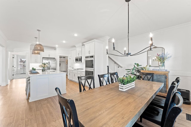 dining area with ornamental molding and light wood finished floors