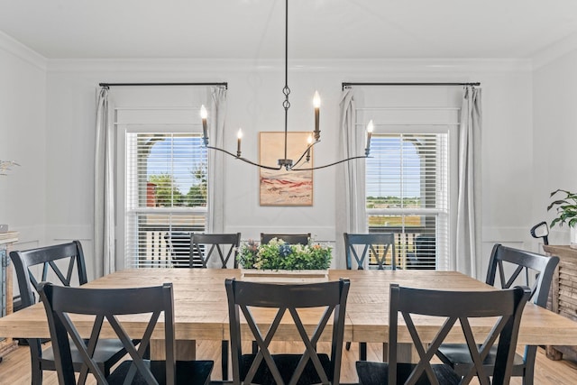 dining space featuring a notable chandelier, crown molding, and wood finished floors