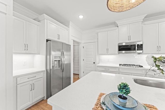 kitchen with stainless steel appliances, light countertops, and white cabinetry