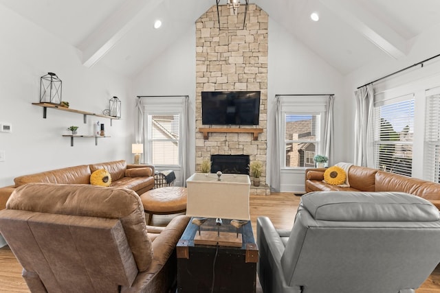 living room featuring a healthy amount of sunlight, a fireplace, wood finished floors, and beamed ceiling