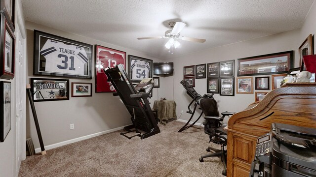 carpeted home office featuring a textured ceiling, a ceiling fan, and baseboards