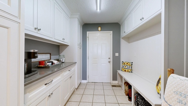 mudroom with a textured ceiling and light tile patterned flooring