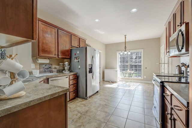 kitchen featuring light tile patterned floors, recessed lighting, hanging light fixtures, appliances with stainless steel finishes, and baseboards