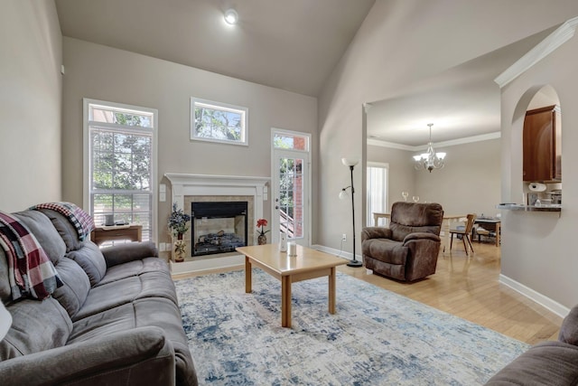 living area featuring ornamental molding, plenty of natural light, light wood-style flooring, and baseboards