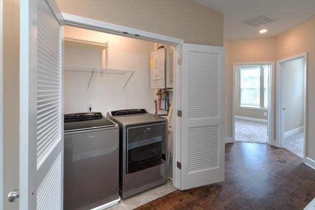 clothes washing area featuring laundry area, baseboards, visible vents, washer and clothes dryer, and dark wood-style flooring