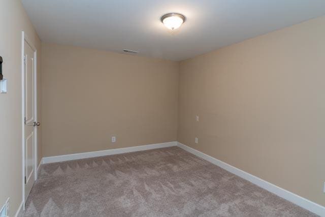 unfurnished room featuring carpet and baseboards