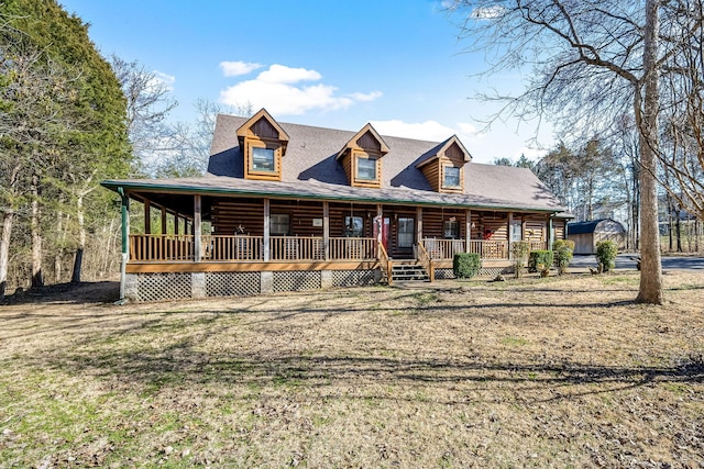 log home with a porch and roof with shingles