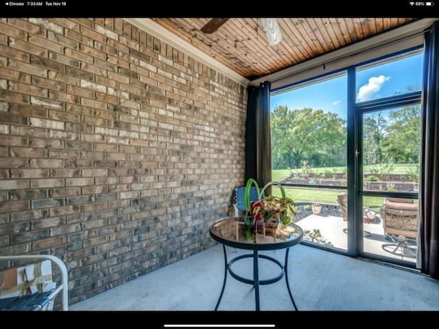 sunroom featuring wood ceiling and ceiling fan