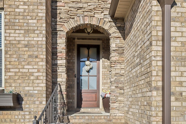 property entrance featuring stone siding and brick siding