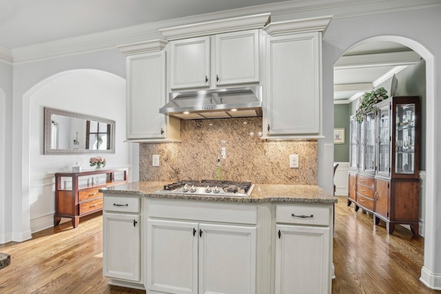 kitchen featuring crown molding, light wood-style floors, stainless steel gas stovetop, and under cabinet range hood