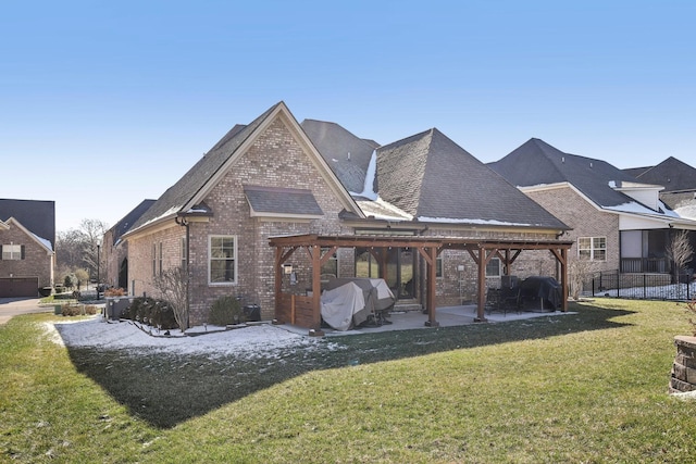 rear view of house featuring a yard, brick siding, a patio, and a pergola