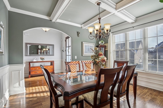 dining area featuring arched walkways, beam ceiling, a healthy amount of sunlight, and wood finished floors