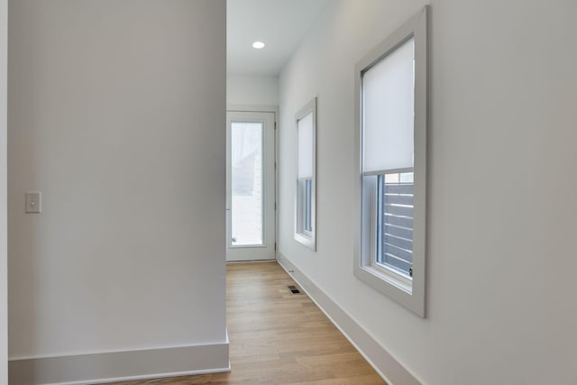 hall featuring recessed lighting, visible vents, light wood-style flooring, and baseboards