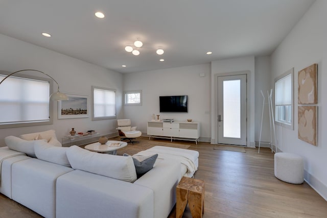 living area with recessed lighting, baseboards, and wood finished floors