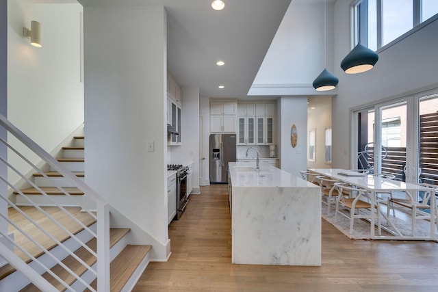 kitchen with stainless steel appliances, recessed lighting, a healthy amount of sunlight, and light wood-style flooring