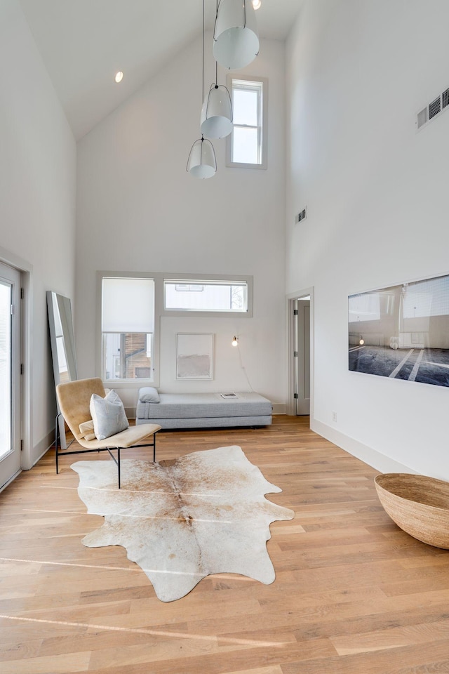 living area with visible vents, baseboards, and wood finished floors