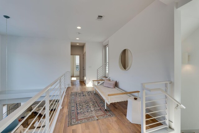 hall with recessed lighting, visible vents, stairway, and wood finished floors