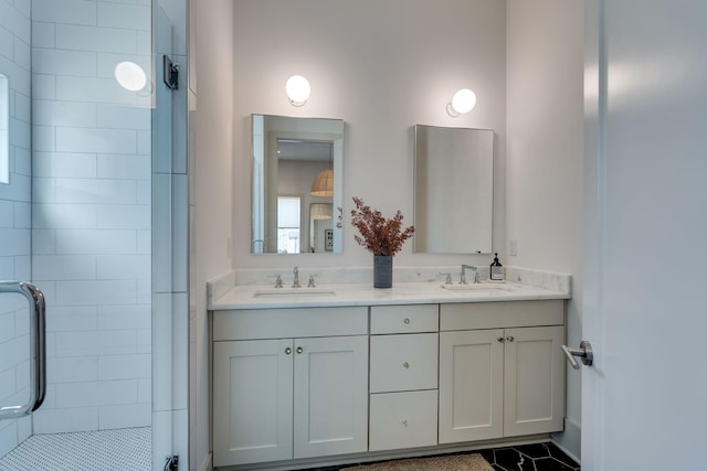 full bath featuring double vanity, a sink, and a shower stall