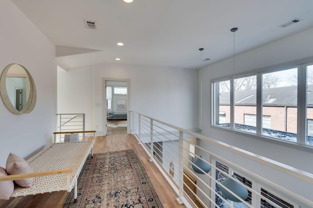 hall featuring recessed lighting, an upstairs landing, visible vents, and light wood-style floors