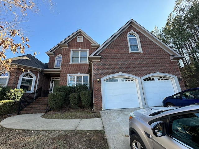 traditional-style home with brick siding, concrete driveway, and a garage